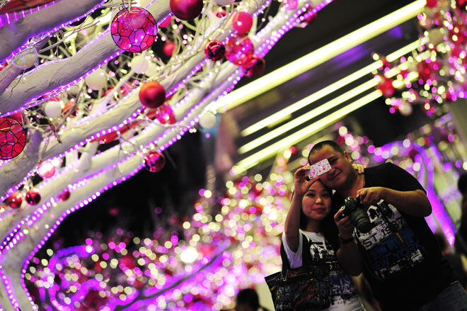 Влюбени се снимат пред Коледната елха в Сингапур
