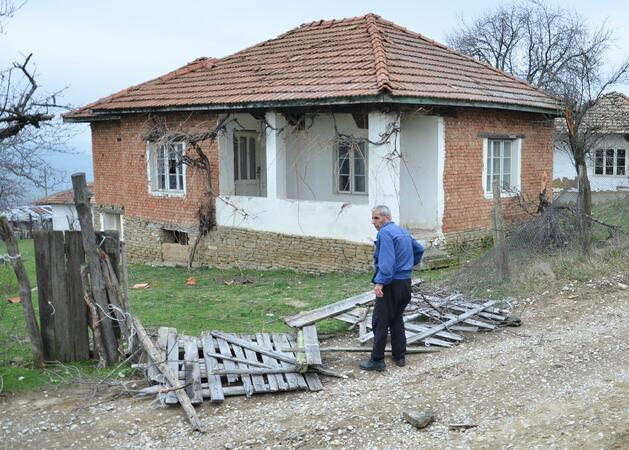 Възрастен мъж оглежда падналата ограда на двора си